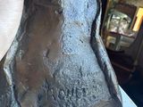 sculpture of a hand holding a piece of metal in a room