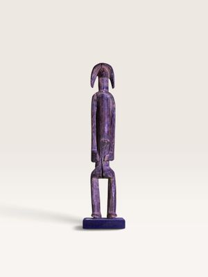 un gros plan d'une figurine représentant une personne posée sur une surface blanche