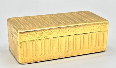une boîte dorée posée sur une surface blanche