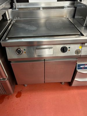 plan de travail en acier inoxydable avec four et lave-vaisselle dans une cuisine professionnelle