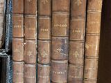 several old books are stacked on top of each other in a box