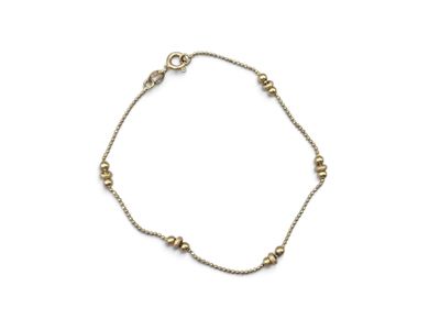 the gold beaded bracelet is shown on a white background