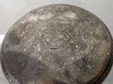 a silver plate with a design on it on a table