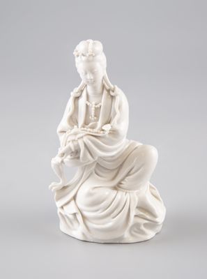 une statue blanche représentant une femme assise sur un rocher