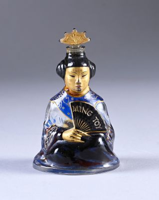 a small glass figurine of a woman holding a fan