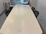 une longue table blanche au milieu d'une pièce