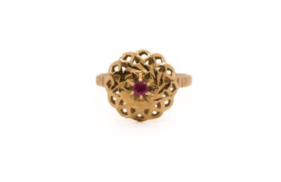a gold ring with a ruby stone surrounded by filigree filigree