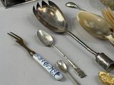 many spoons, forks, and spoon spoons sitting on a table