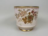 un vase blanc à bord doré avec des fleurs dessus