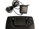 a black game console with a charger on top of it