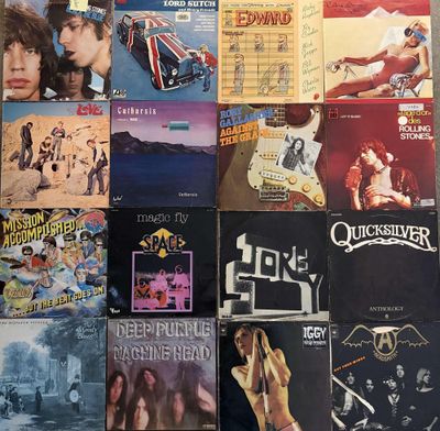 many different album covers on the wall of a room