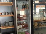 un réfrigérateur dans lequel il y a beaucoup de bouteilles et de verres