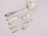 five silver spoons and two silver spoons on a white table