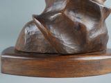 a bronze sculpture of a woman on a wooden base