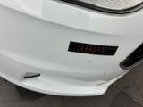 a close up of a white car with a sticker on it