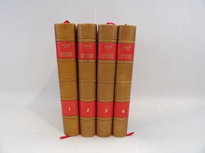 quatre livres marron à la reliure rouge sont empilés les uns sur les autres