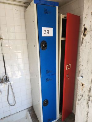 deux casiers dans une salle de bains, avec une pancarte sur la porte