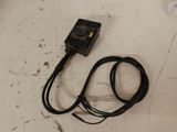 un câble posé par terre à côté d'un chargeur