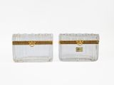 a pair of clear glass boxes with gold trims