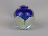 a blue glass vase with a flower inside of it