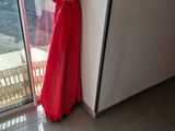 a red umbrella leaning against the wall by the door