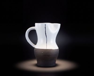 un vase blanc avec un socle noir sur fond noir