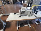 a sewing machine sitting on a table in a warehouse