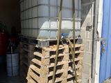 une pile de palettes et un réservoir d'eau dans un garage