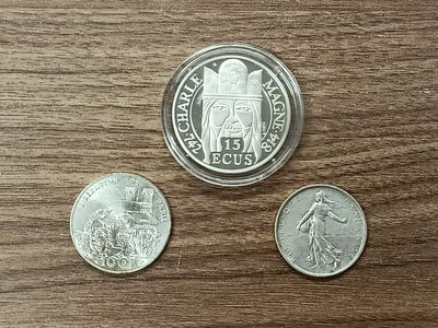 trois pièces de monnaie posées sur une table en bois, avec une pièce au premier plan
