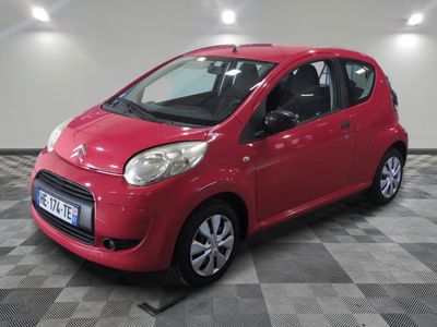 the small red car is parked on a checkered floor