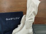a pair of white boots and a bag on the floor