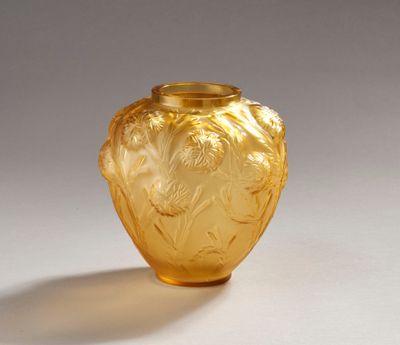 a yellow glass vase with a design on it