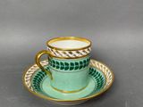 a close up of a cup and saucer on a table