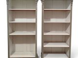 pair of white painted bookshelves with open shelves on each side