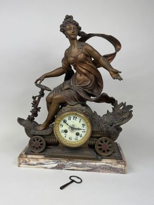 a bronze statue of a woman sitting on top of a clock