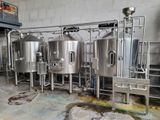 many stainless steel tanks lined up in a room