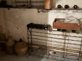a room with a sink and a shelf with baskets on it