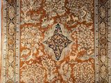an orange and black rug with a medallion design on it