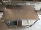 a stainless steel table with two trash cans on it