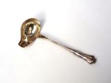 a silver spoon with a spoon handle on a white surface