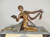 bronze statue of a woman holding a bird on a marble base