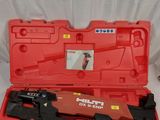 un étui rouge contenant un outil, posé sur une surface blanche