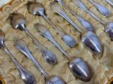 a lot of silver spoons in a box on a table
