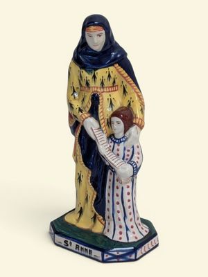 figurine d'une femme tenant un enfant dans ses bras