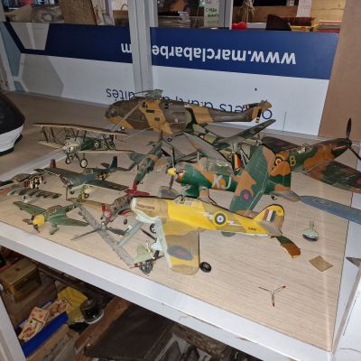 une table sur laquelle sont posés plusieurs petits avions-jouets
