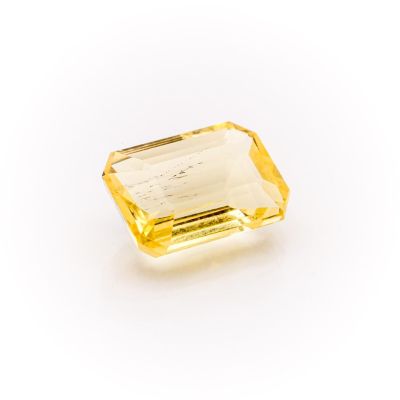 a yellow sapphire stone on a white background
