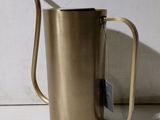 a metal pitcher that has a tag on it