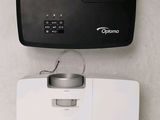 two different views of a projector and a remote control on a wall