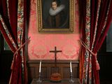 un tableau accroché au mur au-dessus d'une table sur laquelle se trouve une croix