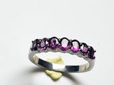 une image représentant une bague ornée de pierres violettes sur un fond blanc